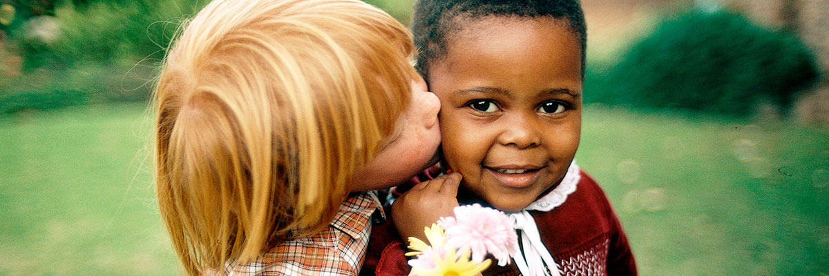 Дети не знают расизма. Белый ребенок в знак дружбы обнимает темнокожего ребенка. Кейптаун, Южная Африка. Фото ООН