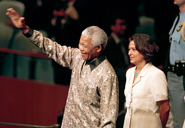 Nelson Rolihlahla Mandela (left), President of South Africa, enters General Assembly Hall to address its fifty-third session. He is flanked by UN Chief of Protocol, Nadia Younes.