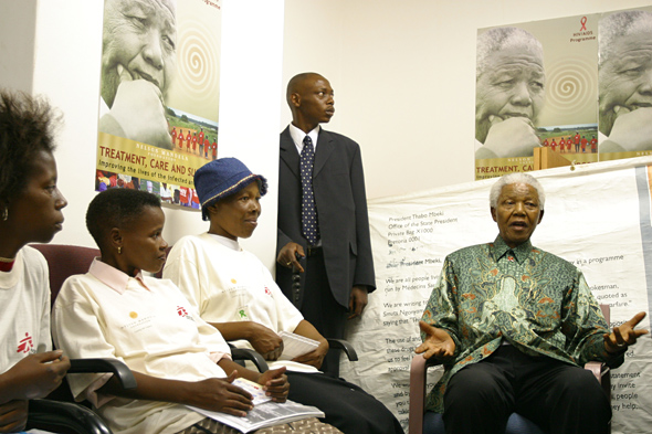 Mr. Mandela addressing women in a room with HIV/AIDS posters, taken during meetings about HIV/AIDS in November 2004.