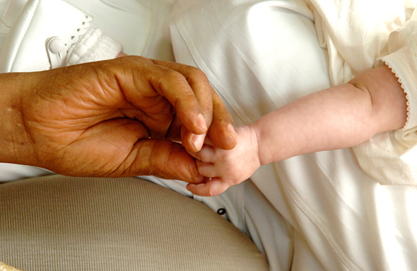 Les mains de Nelson Mandela et d'un bébé. © Photo NMF/Peter Morey
