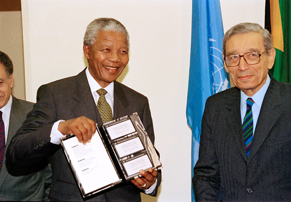 Nelson Mandela (à gauche) tient dans ses mains un livre offert par le Secrétaire Général Boutros Boutros-Ghali. Le livre traite des Nations Unies et des efforts menés par l'Organisation dans la lutte contre l'apartheid. © Photo ONU/James Bu