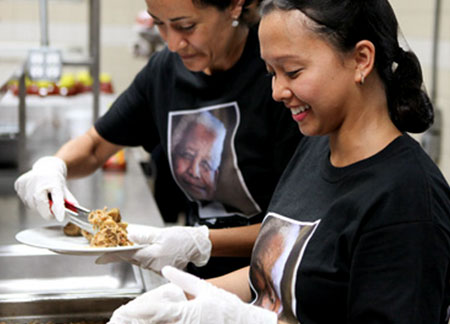 Deux membres du personnel des nations Unies, volontaires à la Mission Bowery, en train de servir des repas aux plus démunis