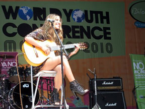 young woman playing guitar on stage