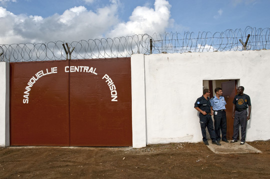 Two UN corrections officers talk to their Liberian counterpart at the newly completed Sanniquellie Corrections Center in Sanniquellie, north-east Liberia, built with funds from UNMIL and the UN Peacebuilding Fund, 2010.  UN Photo/Staton Winter