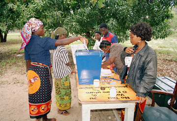 Una mujer deposita su cédula de votación en una mesa electoral rural en Catembe, Mozambique durante el segundo día de elecciones.