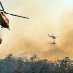 Helicopter dumping water on forest fire