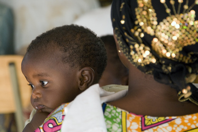 Une femme tenant son bébé dans les bras.