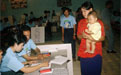 Une électrice avec son enfant dans un bureauvote au Cambodge