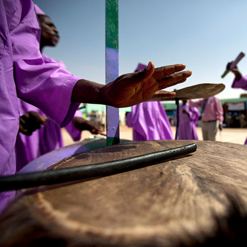 在苏丹首都法希尔，非盟-联合国达尔富尔混合行动的联合国机构和达尔富尔人民聚集在一起，以游行、舞蹈、演唱和平歌曲等形式纪念联合国日，摄于2012年。联合国图片/Albert González Farran