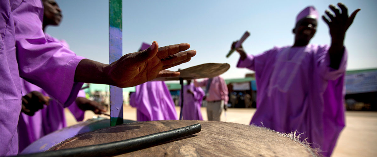 在苏丹首都法希尔，非盟-联合国达尔富尔混合行动的联合国机构和达尔富尔人民聚集在一起，以游行、舞蹈、演唱和平歌曲等形式纪念联合国日，摄于2012年。联合国图片/Albert González Farran