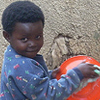 A young girl washes the dishes.