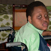 A young girl with Down syndrome sits in a wheelchair.