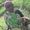 An older woman walks along the road.