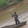 Two men canoe down the river.