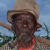 A portrait of an older man smoking a pipe after spending the day working in the fields.