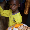 A young boy carries the eggs he will sell for the day.