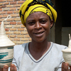 A woman holds the baskets that she has made.