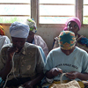 A group of women weave baskets.