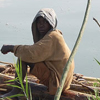 A young boy catches fish in the lake.