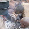 Two children start a fire for cooking.