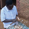 A woman cuts cassava for dinner. 