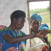 Xaverina reads from the bible while conducting the funeral for a young woman in her community who recently died of malaria. Many people see Xaverina as a leader in their community and she was asked to perform this burial.